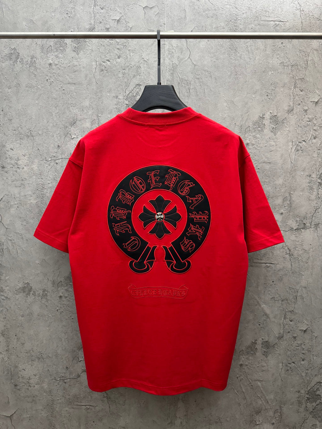Red short-sleeve T-shirt with large back circular emblem, crew neck.