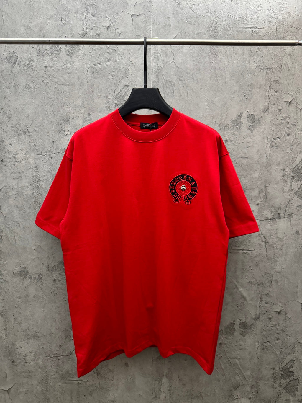 Red short-sleeve T-shirt with chest emblem graphic, crew neck.
