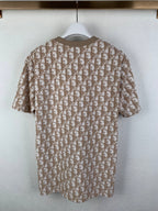 Tan short-sleeve top with repeating logo pattern on the back