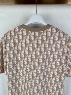 Back view of tan short-sleeve top with repeating logo print