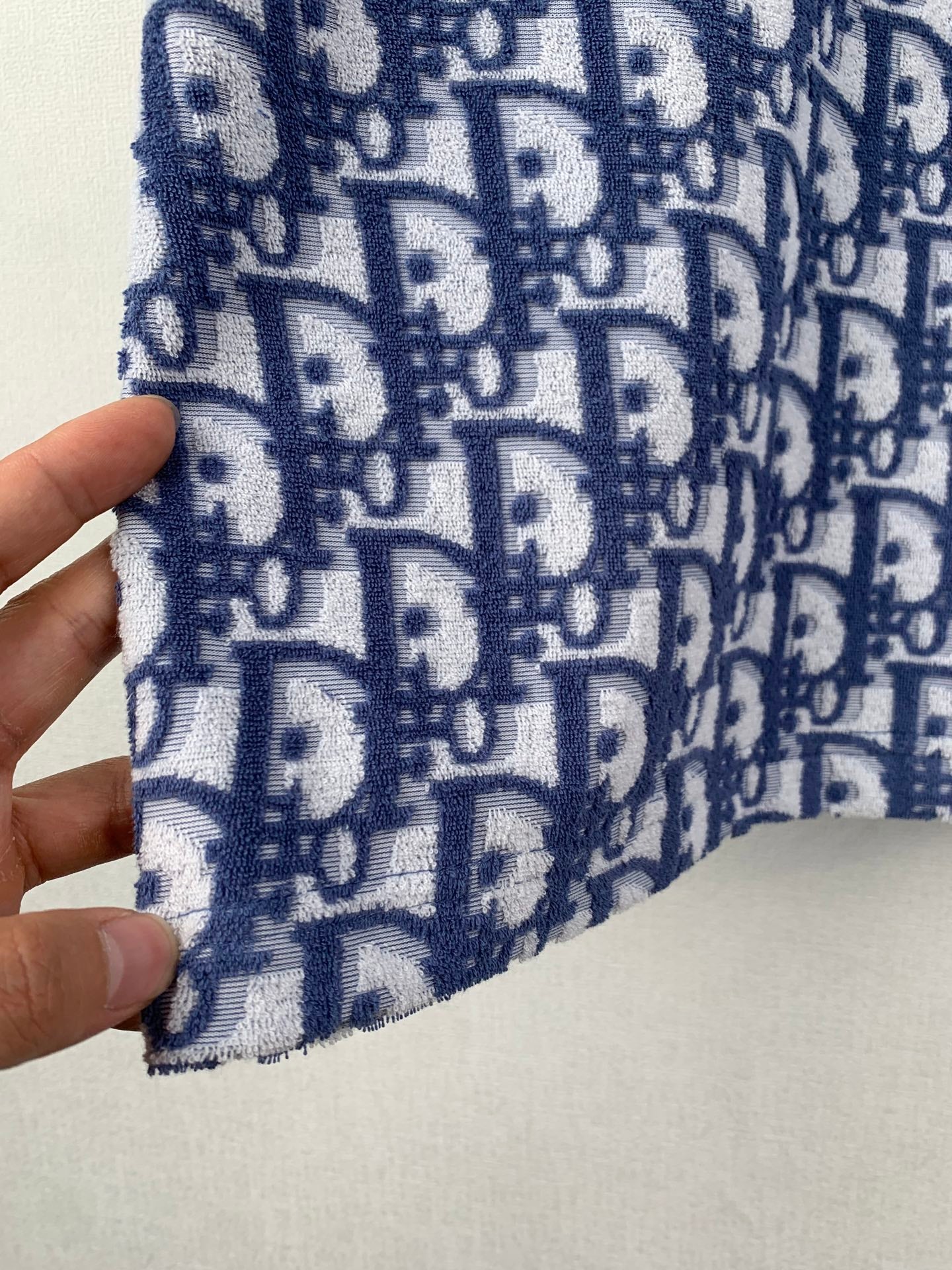 Navy-and-white logo knit fabric close-up with repeating pattern