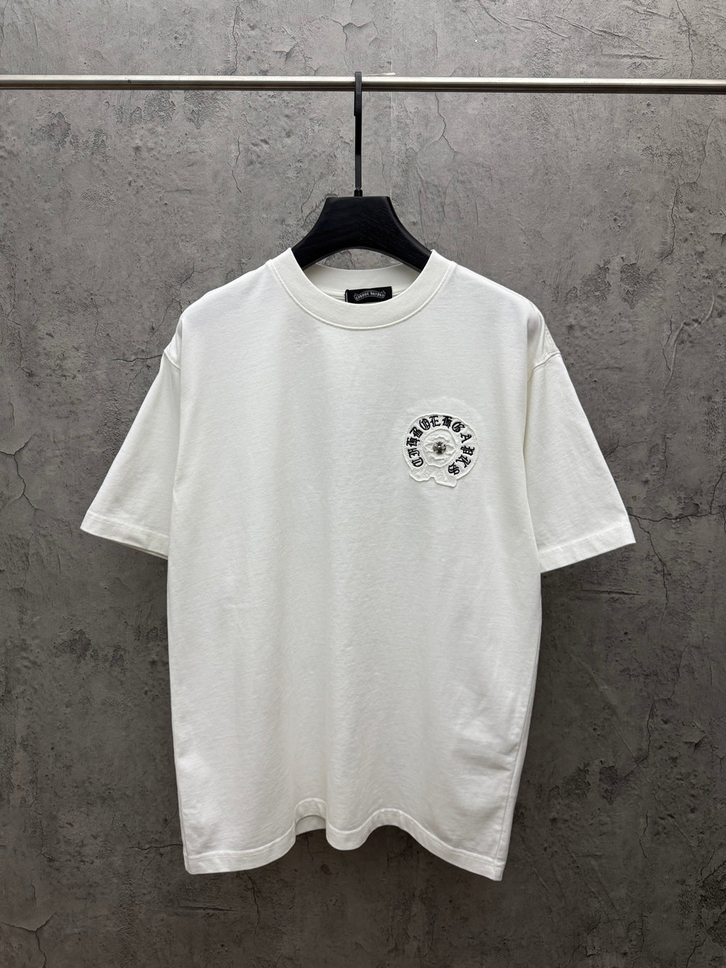 White short-sleeve T-shirt with small circular embroidered chest logo