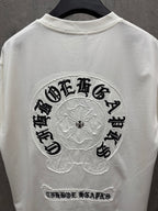 White T-shirt back view with large circular embroidered logo and small bottom text