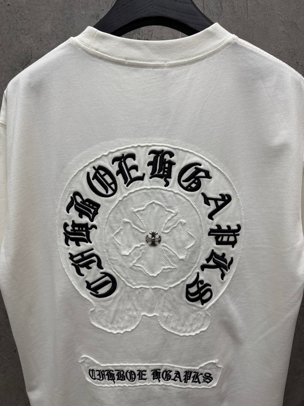 White short-sleeve T-shirt with large back logo and lower slogan text