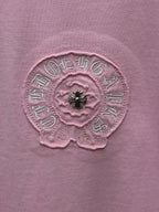 Pink short-sleeve T-shirt close-up of embroidered flower emblem with black bead