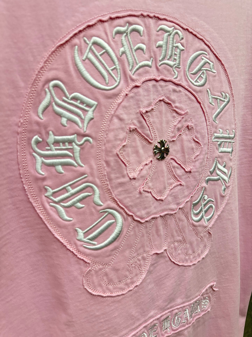 Pink T-shirt close-up of large back embroidered circular crest and beaded center
