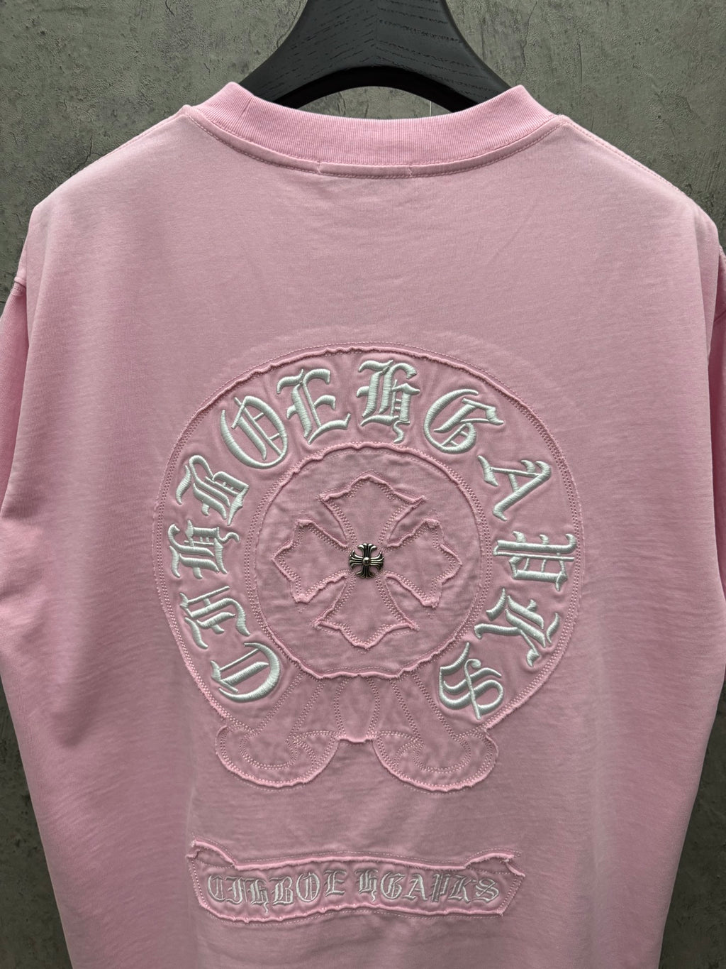 Pink short-sleeve T-shirt back view with large circular embroidered graphic