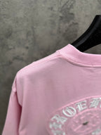 Pink T-shirt back partial view with embroidered emblem near hem