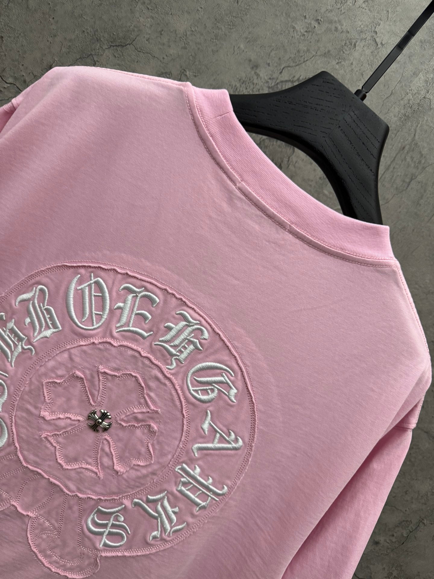 Pink short-sleeve T-shirt close-up of large back circular embroidered design