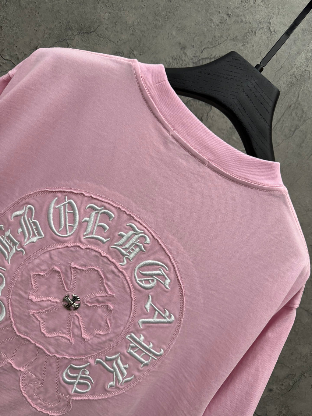 Pink T-shirt close-up of back embroidered circular logo