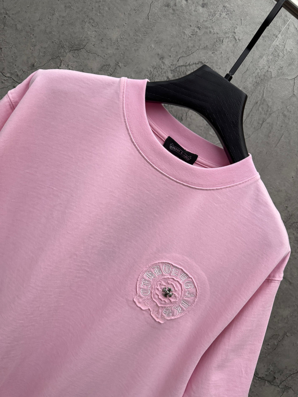 Pink T-shirt close-up of ribbed crew neck and left-chest embroidered emblem