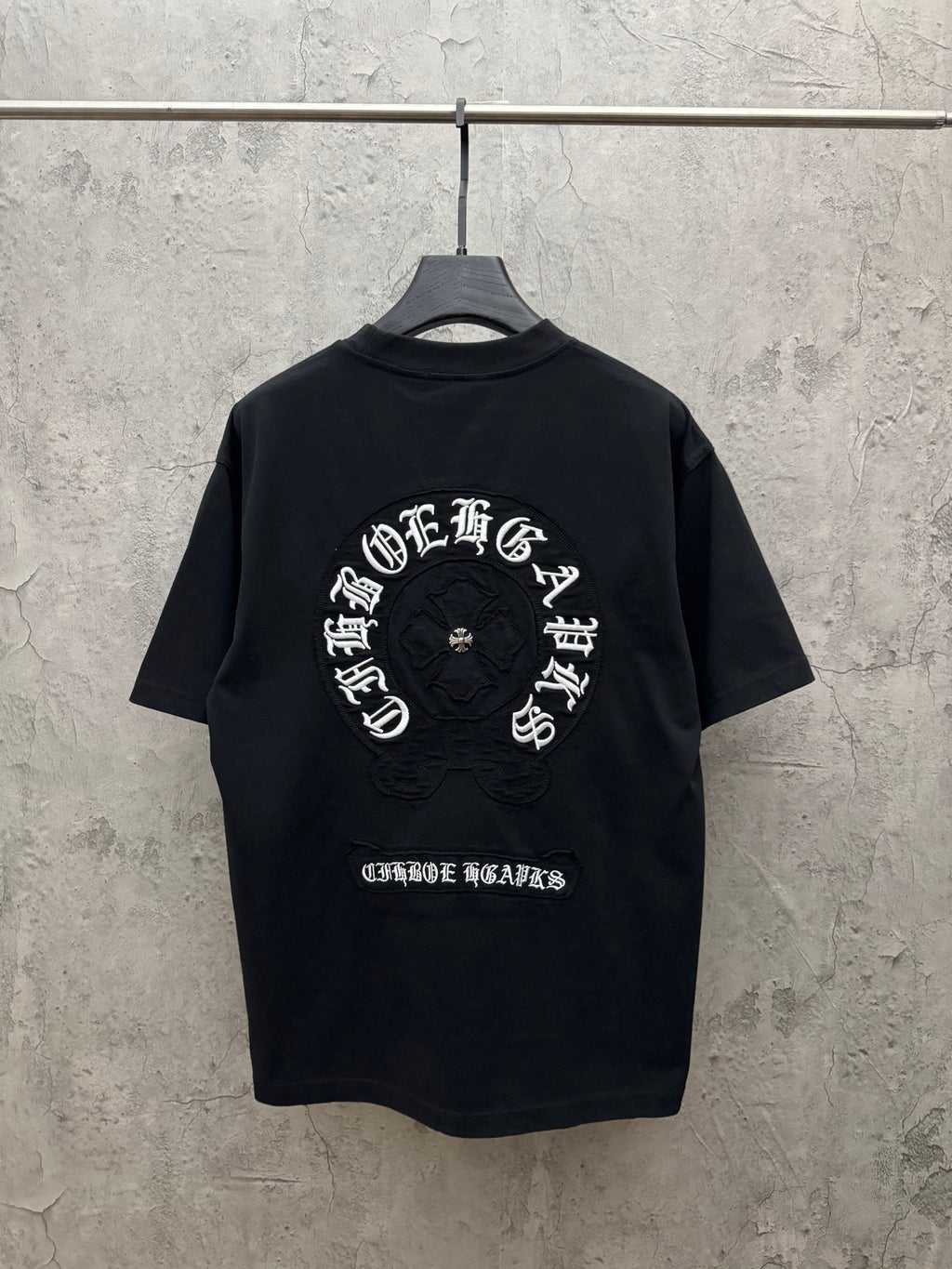 Black short-sleeve crewneck T-shirt with large back circular embroidered graphic