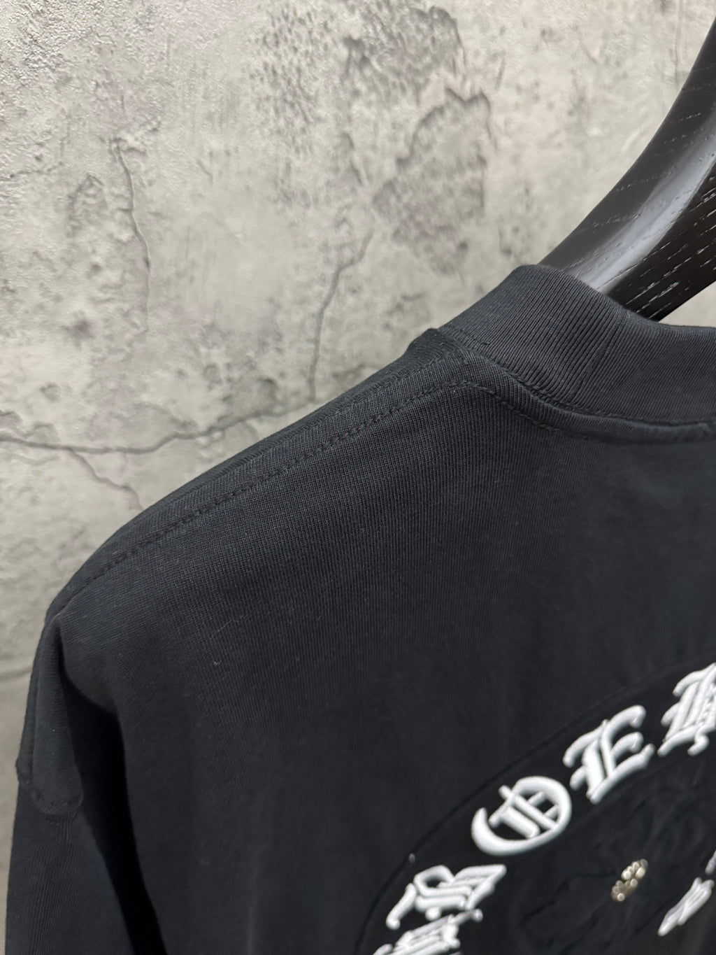 Chrome short-sleeve T-shirt back corner with embroidered text and dark fabric