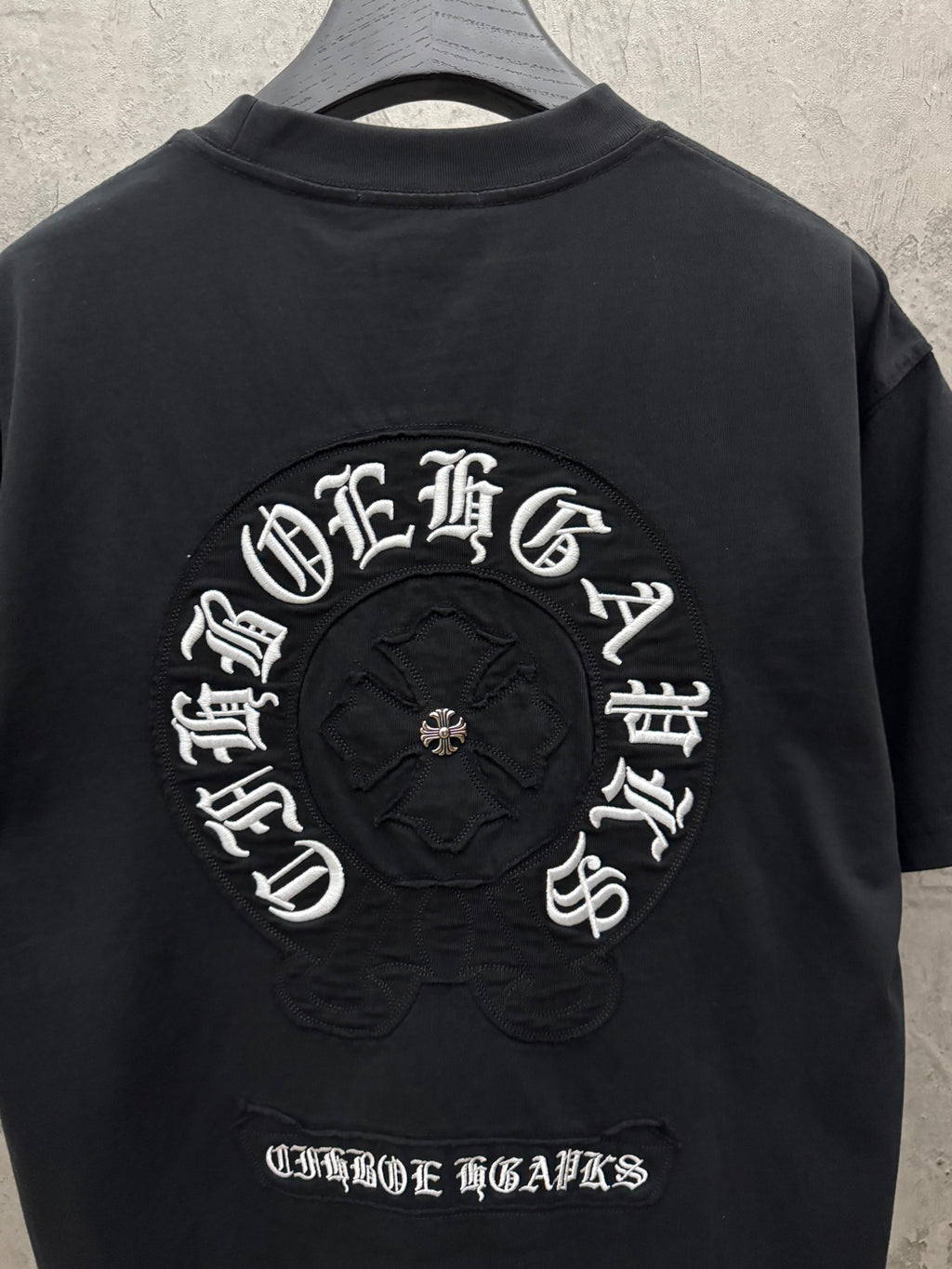 Black short-sleeve crewneck T-shirt with large back embroidered circular logo