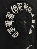 Chrome short-sleeve T-shirt close-up of circular embroidered logo with gold center