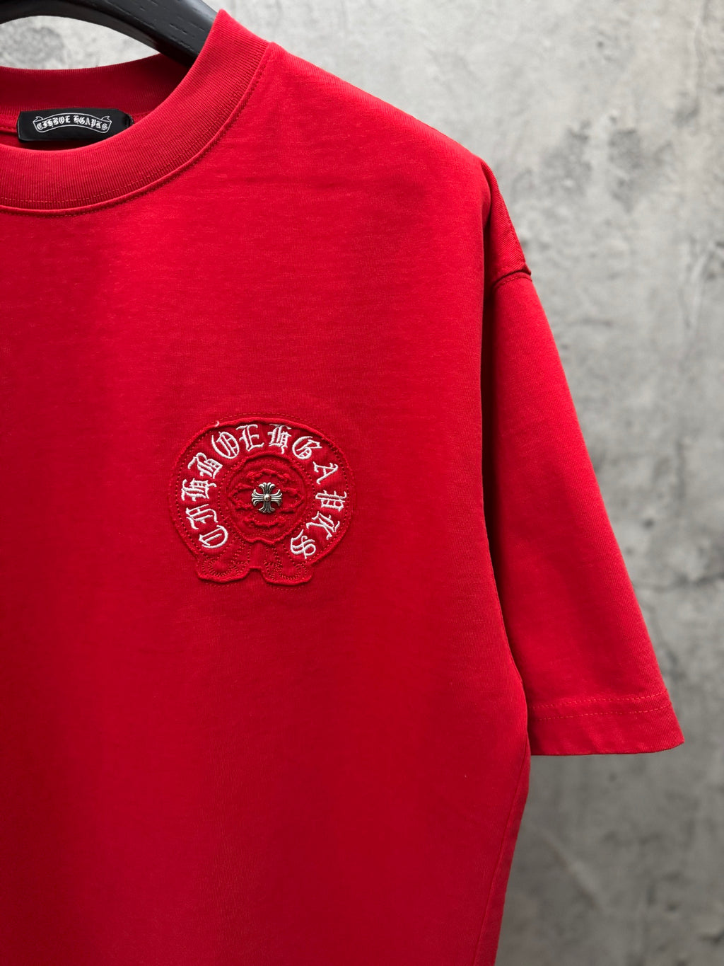 Red crewneck T-shirt with small chest embroidered crest and visible hem