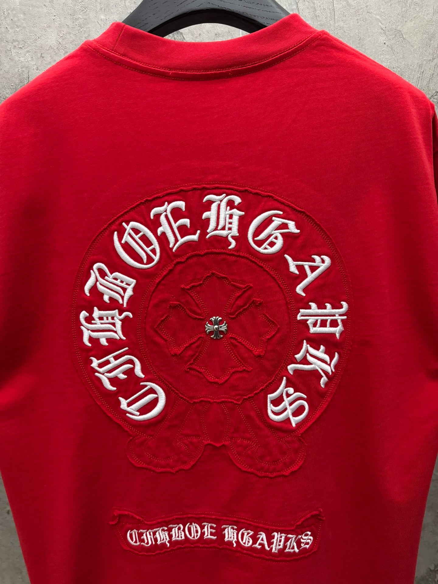 Red short-sleeve T-shirt back with circular logo and arched text