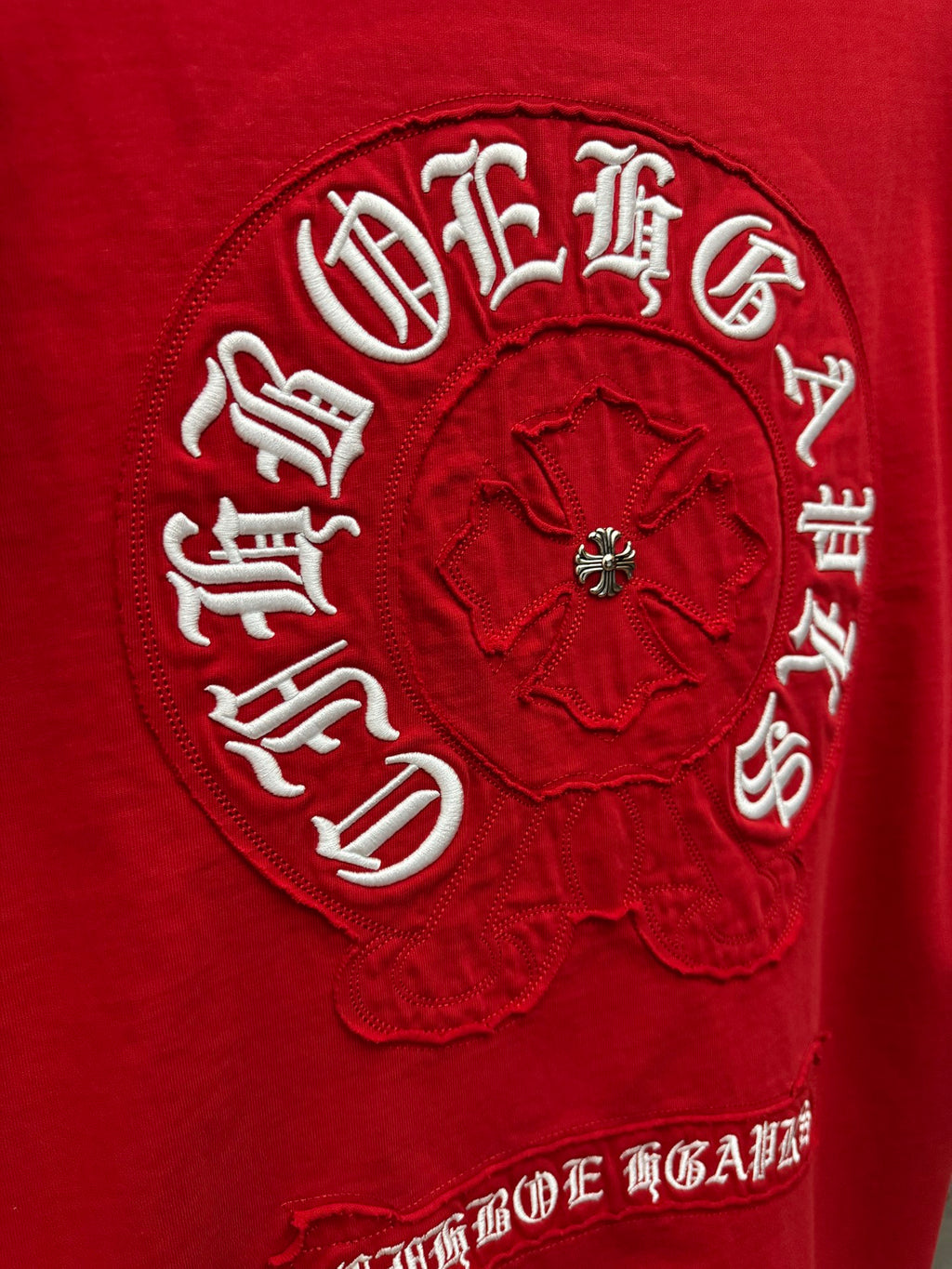 Close-up of red T-shirt logo patch with circular emblem