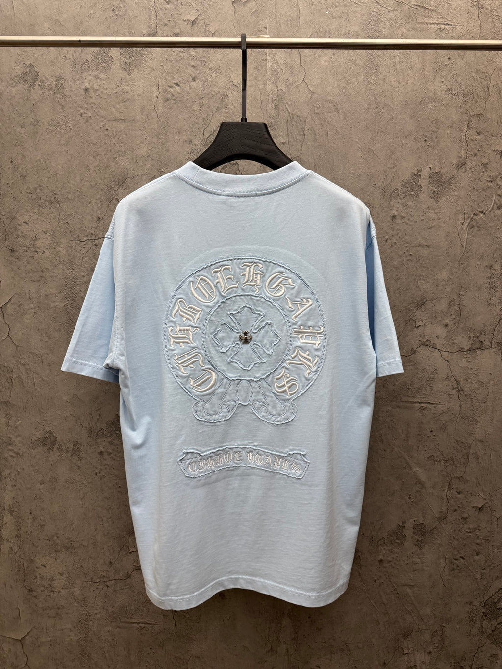 Light blue crewneck short-sleeve T-shirt with large back embroidered crest and text