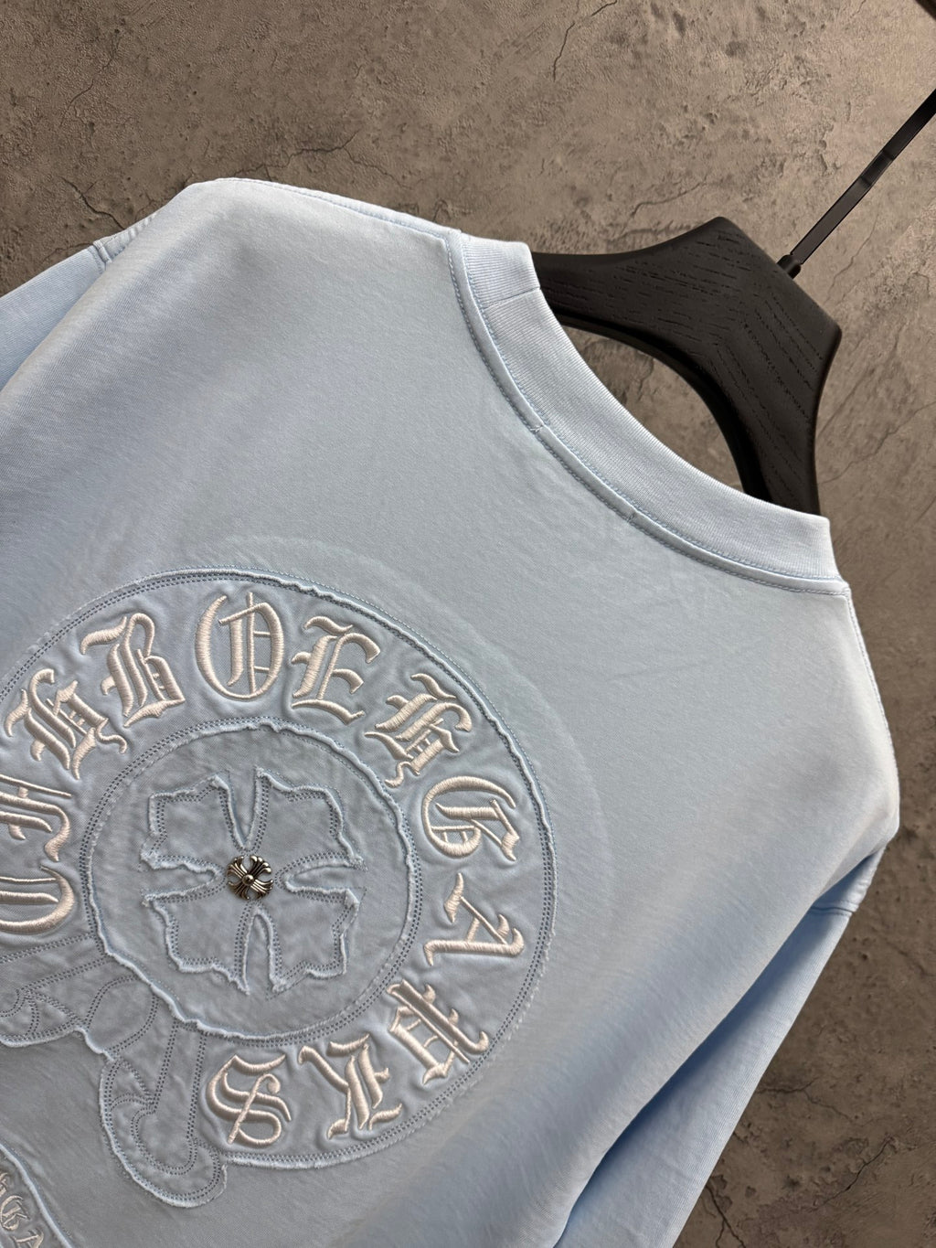 Light blue short-sleeve T-shirt close-up of large embroidered back design