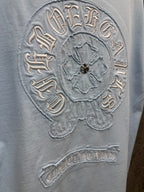 Light blue short-sleeve T-shirt close-up of embroidered back crest with ring text