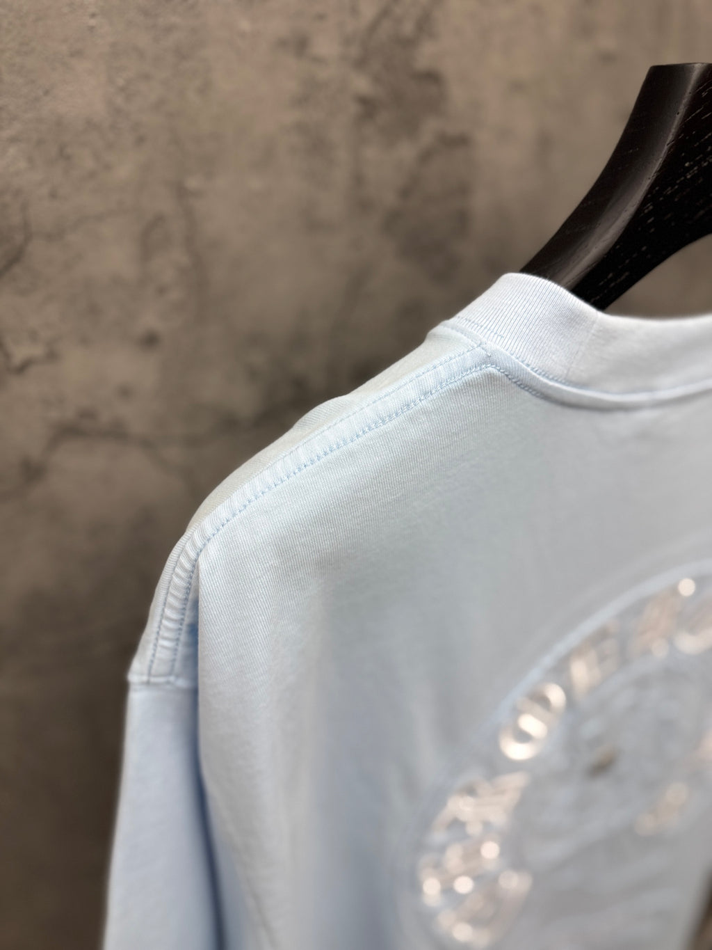 Light blue T-shirt close-up of shoulder seam and crew neckline