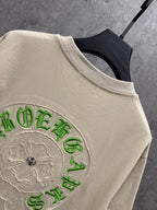 Cream T-shirt sleeve/shoulder with detailed green embroidered back crest