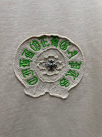 Close-up of cream fabric with green and gray embroidered crest patch