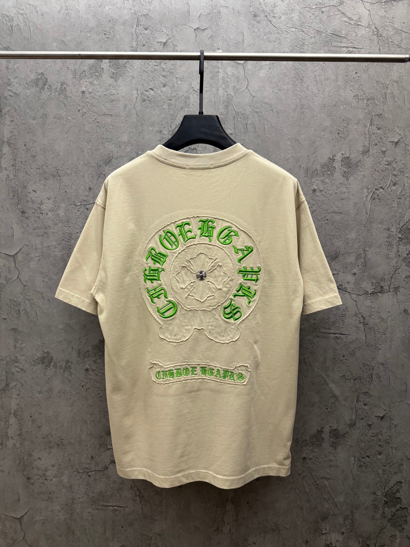 Light cream T-shirt with large green embroidered back graphic and floral patch