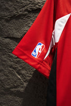 Red Balenciaga jersey sleeve with NBA team patch on the short sleeve cuff