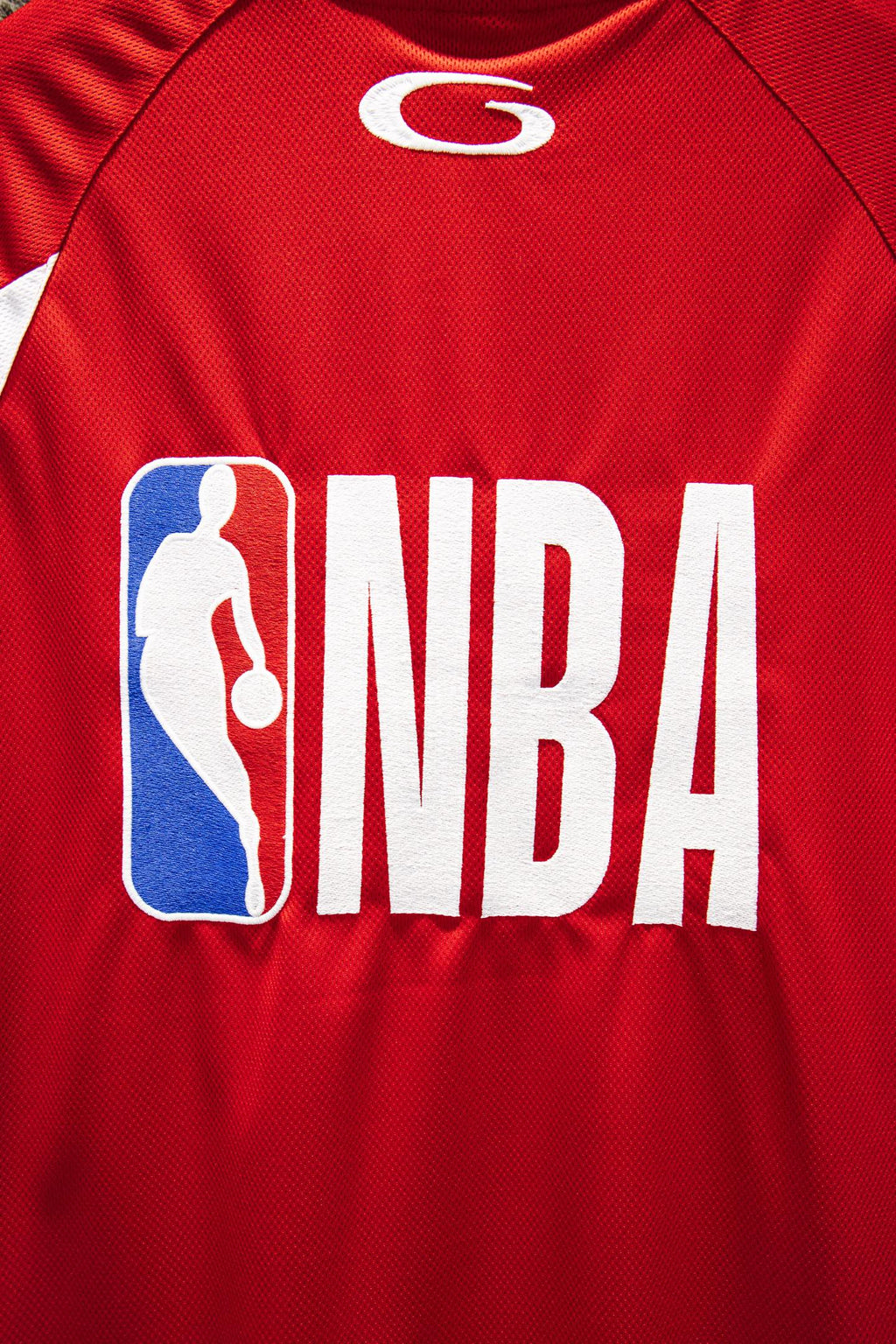 Red Balenciaga jersey detail with NBA logo and silhouetted player graphic