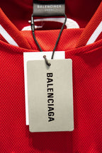 Red Balenciaga jersey with white neck label reading BALENCIAGA, on black clips