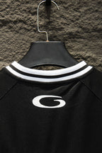 Black short-sleeve jersey neckline with white striped collar and oval G emblem