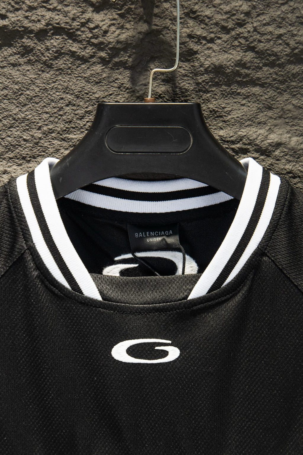 Black collar of short-sleeve jersey with white-and-gray striped trim and G emblem