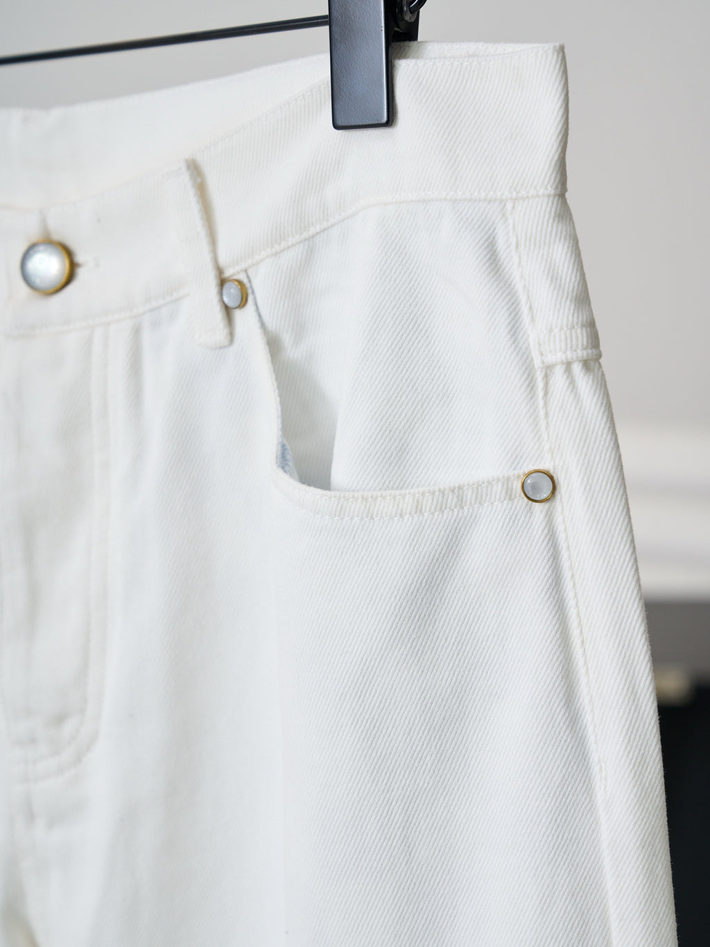 Louis Vuitton white denim pants with curved pocket opening and button detail