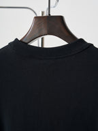 Black crewneck sweatshirt neckline detail on wooden hanger