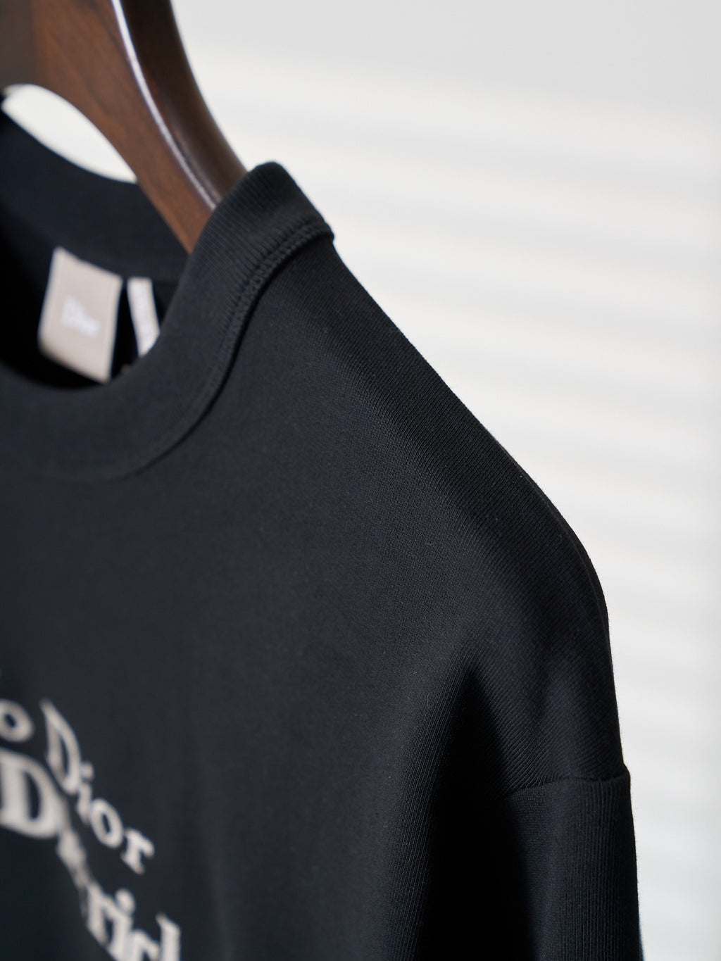 Black crewneck sweatshirt shoulder seam and neckline detail