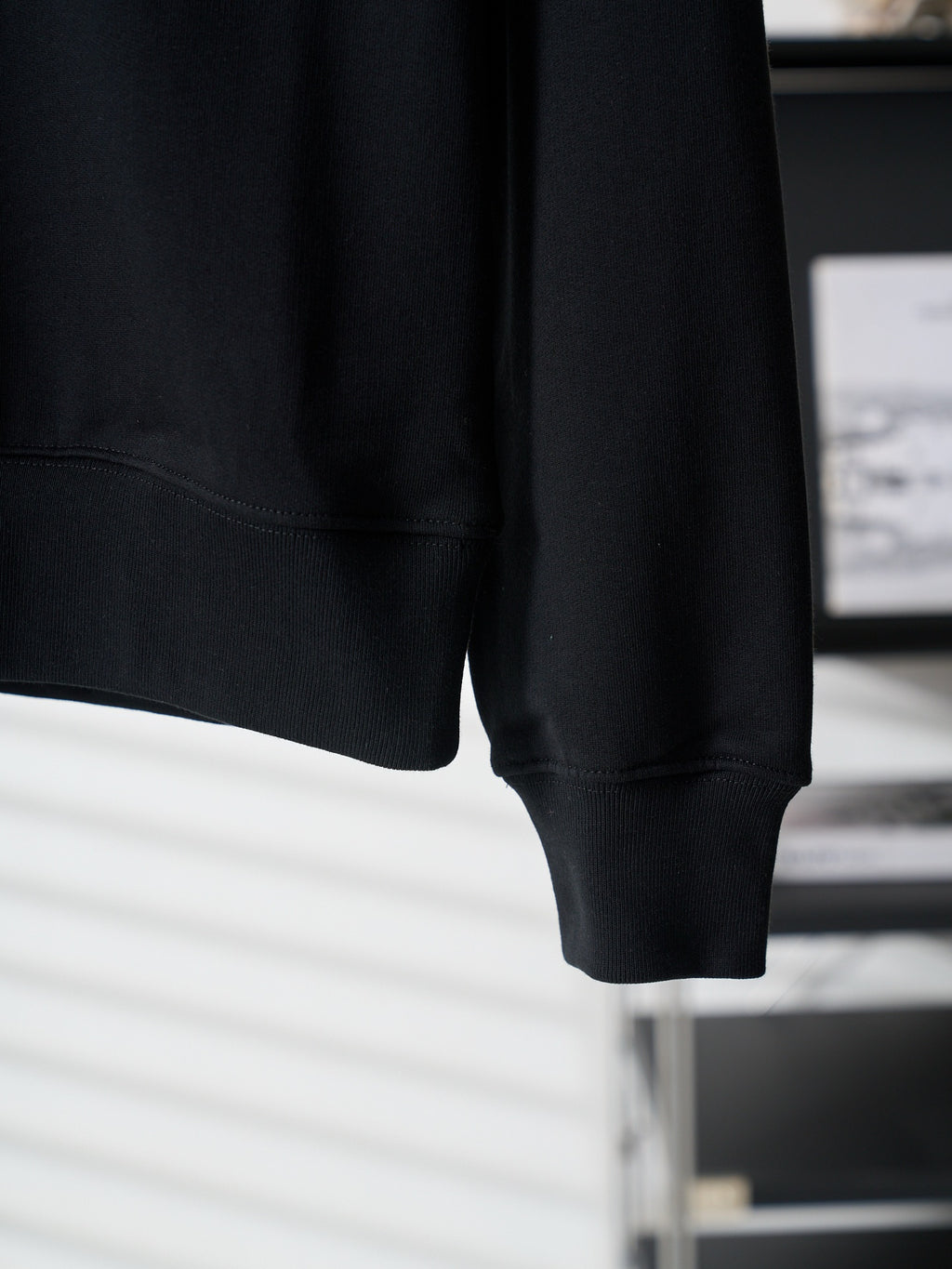 Black crewneck sweatshirt sleeve cuff and straight hem detail