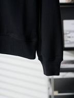 Black crewneck sweatshirt sleeve cuff and straight hem detail