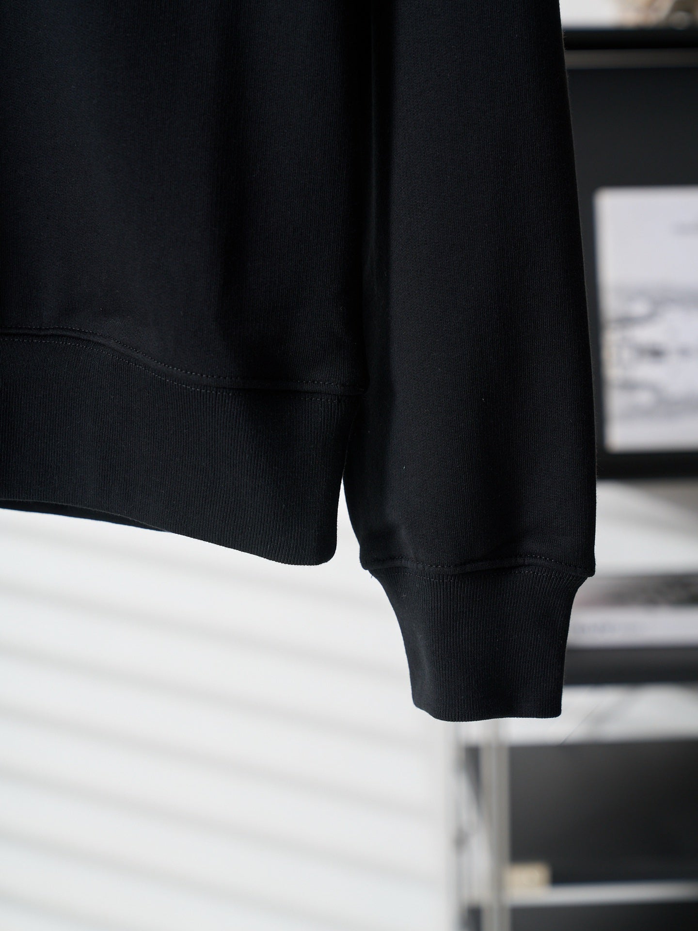 Black crewneck sweatshirt sleeve cuff and straight hem detail