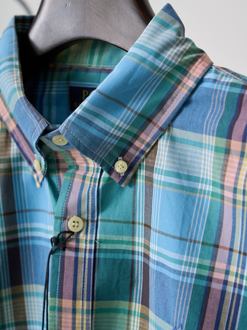 Turquoise plaid shirt collar and button placket detail with neck tape