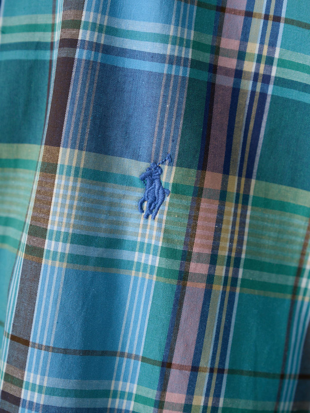 Blue-green plaid shirt with small embroidered crest on chest