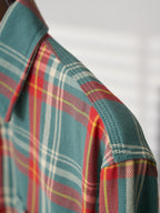 Plaid shirt shoulder seam detail in teal with red, green, and white stripes