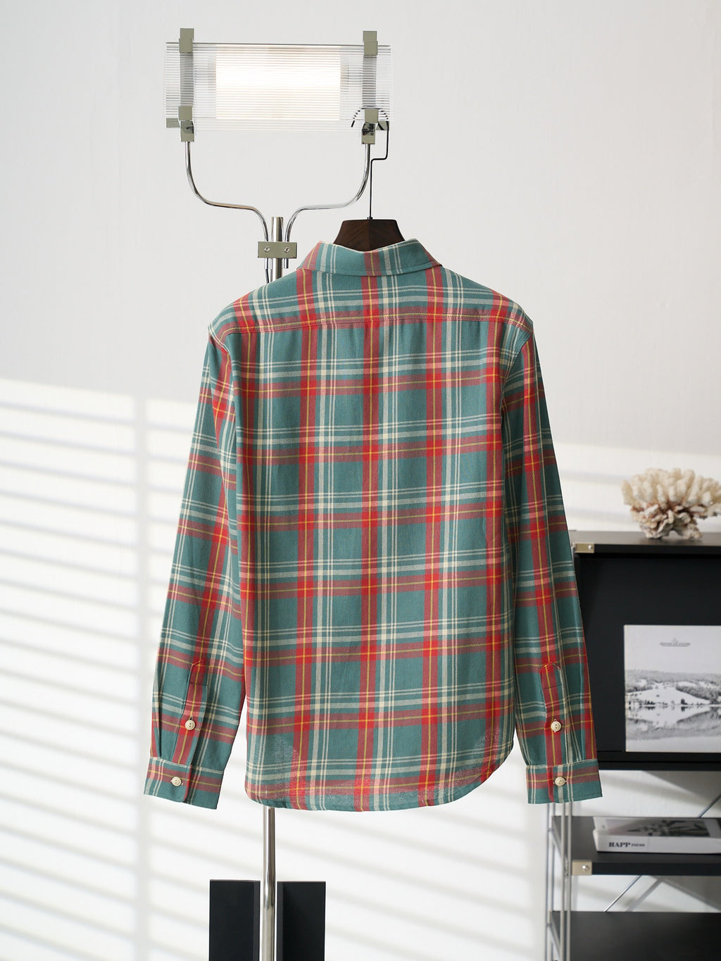 Teal plaid button-up shirt, back view, hanging with white buttons along center