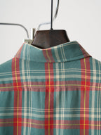 Teal plaid shirt neckline and yoke detail on hanger, no front closure visible