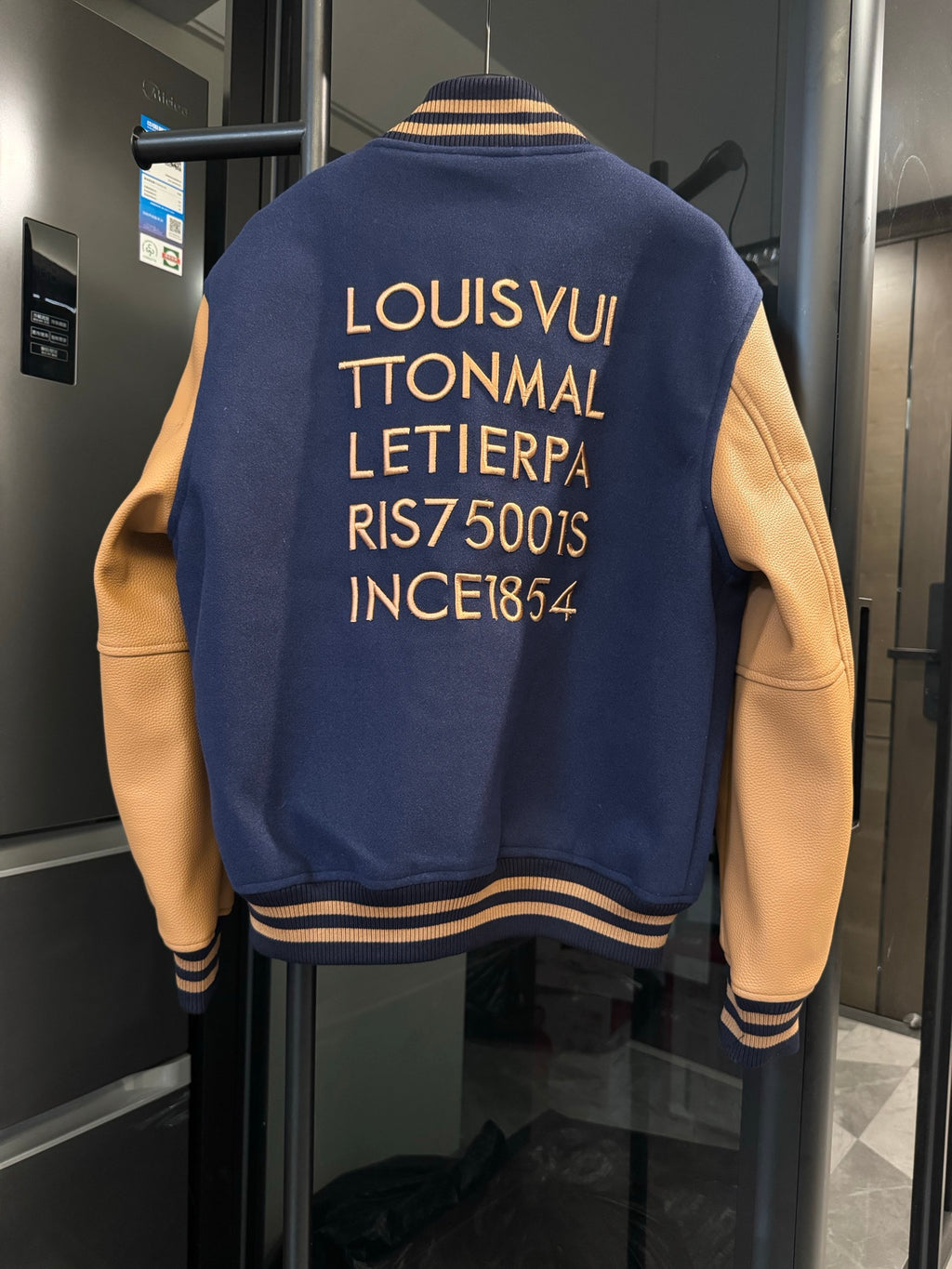 Long varsity jacket back in dark navy with gold text and striped rib collar