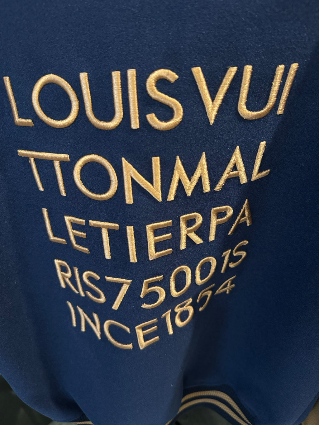Long varsity jacket back with large gold lettering and numbers