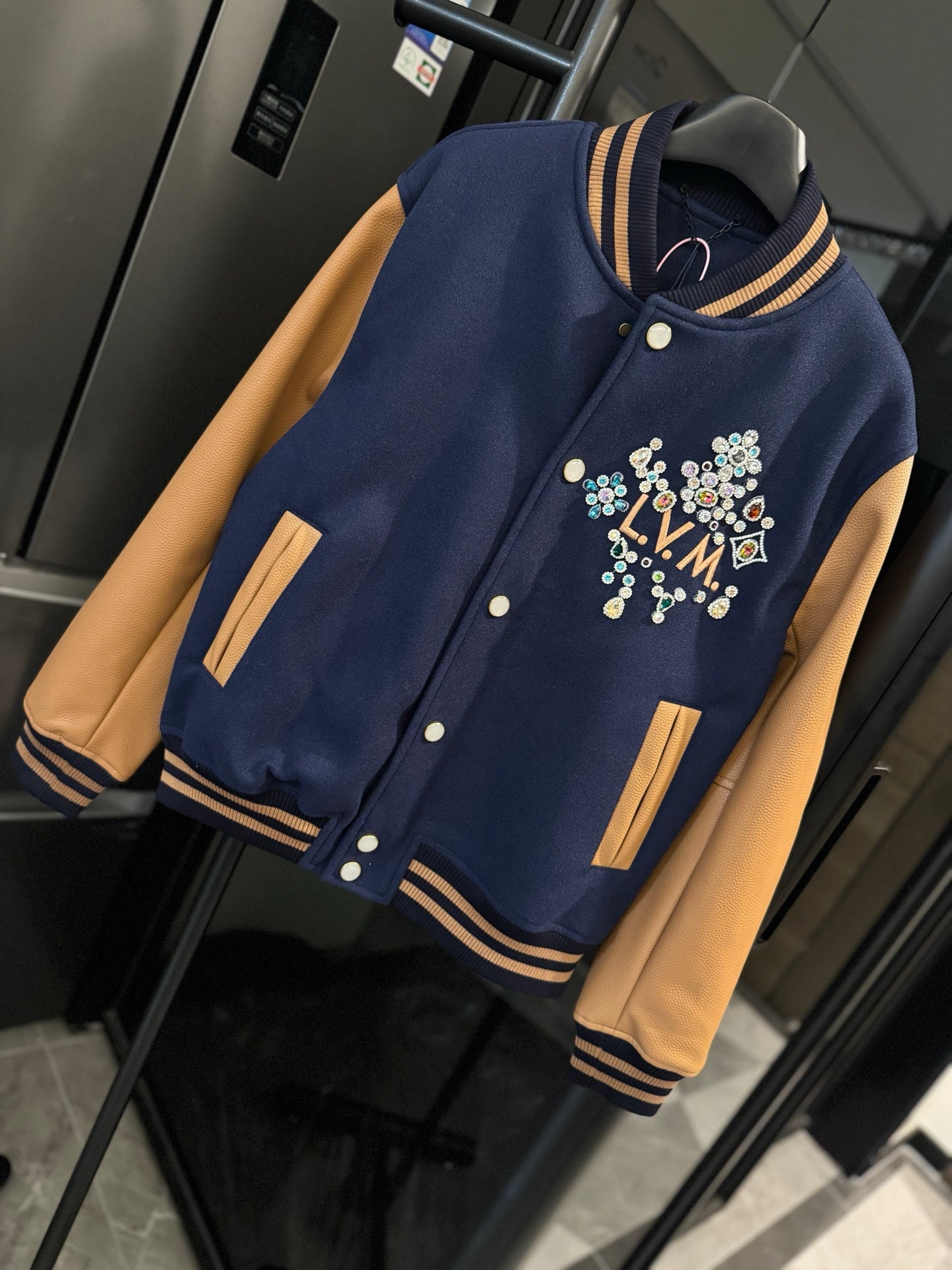 Long varsity jacket with multicolor LV crest, tan pocket accents, striped cuffs and hem