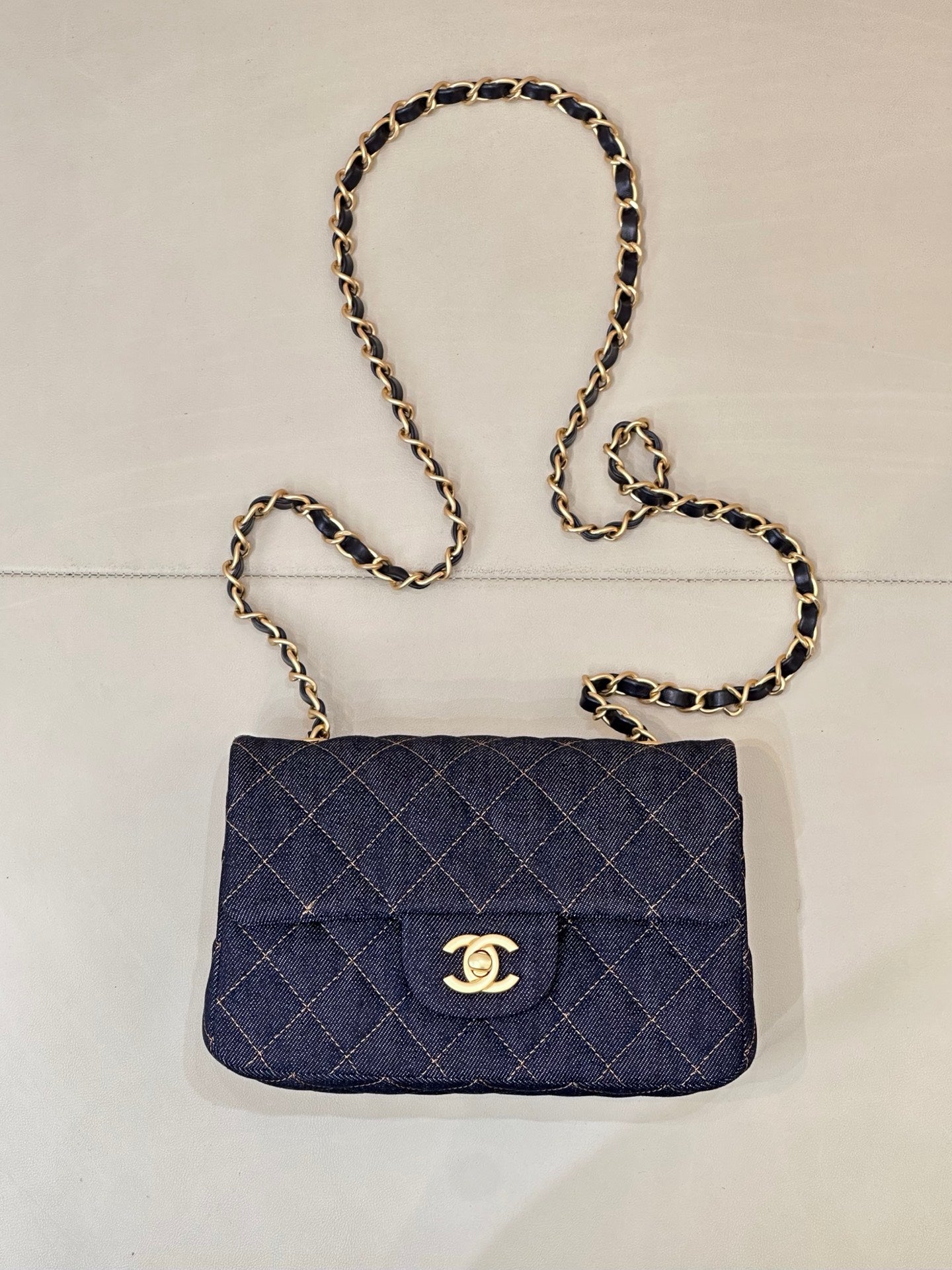 Chanel quilted denim shoulder bag with flap and gold CC logo, chain strap.