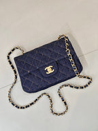 Chanel quilted denim crossbody bag with gold CC logo and curb chain strap.
